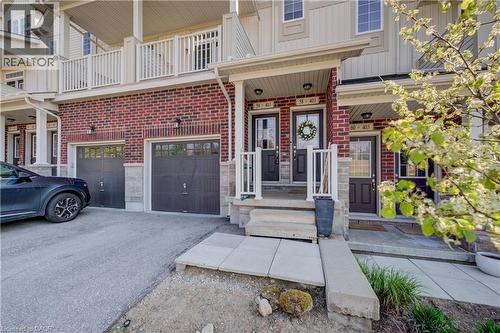 Multi-level townhouse exterior featuring red brick and light-toned siding - 403 Westwood Drive Unit# 59, Kitchener, ON 