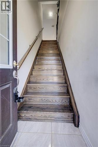 Wood-finish staircase with a coordinating handrail and light-colored wall paint - 403 Westwood Drive Unit# 59, Kitchener, ON 
