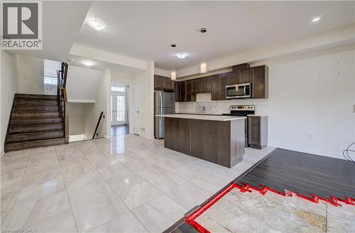 Open-concept space featuring a kitchen with dark cabinetry, stainless steel appliances, and a central island - 403 Westwood Drive Unit# 59, Kitchener, ON 