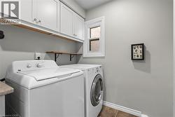 White upper cabinetry, open shelving, window with white trim, and tile flooring - 