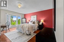 Wood-finish flooring, bay window, ceiling fan with light fixture, and a bold accent wall - 