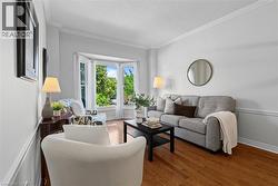 Hardwood flooring, bay windows, crown molding, chair rail, and neutral wall tones - 