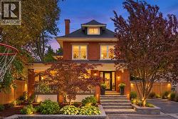 Brick exterior with a prominent front entrance, featuring a covered porch with white railing, and a gabled dormer - 