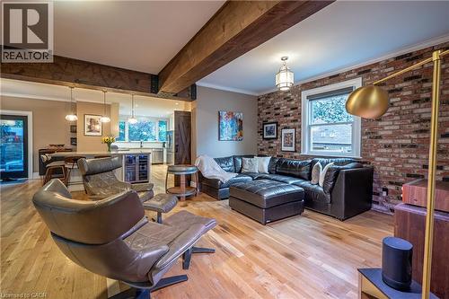Exposed wood beams, wood-finish flooring, brick-accent wall, and recessed lighting - 283 Plains Road W, Burlington, ON 