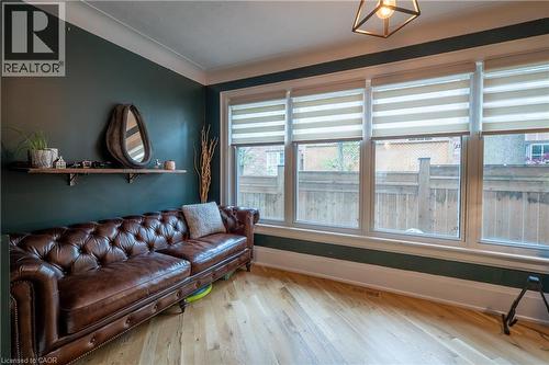 Hardwood flooring, painted walls, crown molding, a wood-finish floating shelf, and multiple windows - 283 Plains Road W, Burlington, ON 