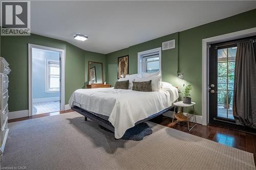 Hardwood flooring, wall-mounted sconce, and French door - 283 Plains Road W, Burlington, ON 