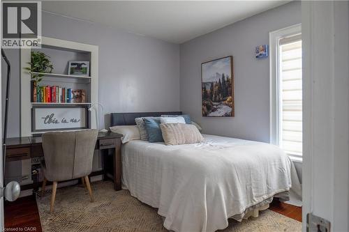 Recessed built-in shelving, wood-finish flooring, and a white-framed window with shades - 283 Plains Road W, Burlington, ON 