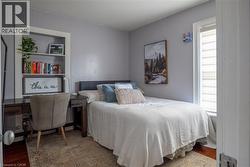 Recessed built-in shelving, wood-finish flooring, and a white-framed window with shades - 