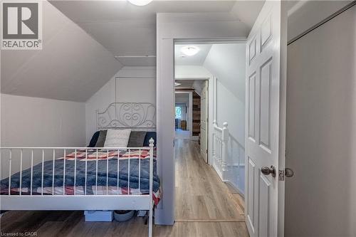Angled ceilings in bedroom with wood-finish flooring - 283 Plains Road W, Burlington, ON 