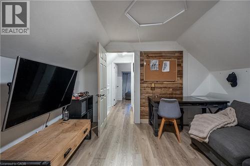 Sloped ceilings, wood-finish flooring, accent wall, paneled interior door, built-in shelving - 283 Plains Road W, Burlington, ON 