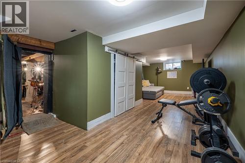 Wood-finish flooring, white barn door, and recessed lighting - 283 Plains Road W, Burlington, ON 
