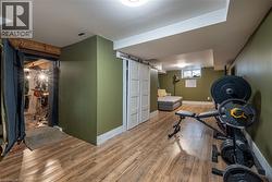 Wood-finish flooring, white barn door, and recessed lighting - 