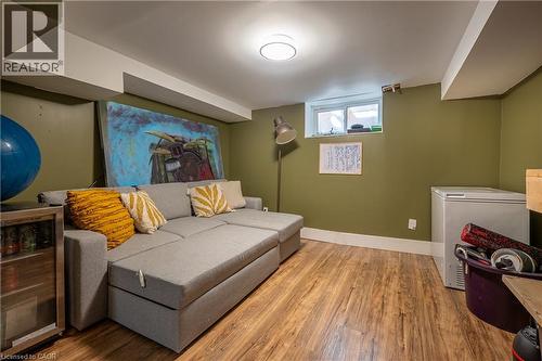 Warm wood-finish flooring with a white trim, recessed window, and flush-mount ceiling light - 283 Plains Road W, Burlington, ON 