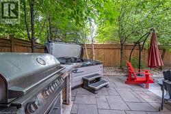 Patio with stone pavers, built-in grill station, and an outdoor spa - 