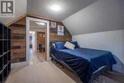Attic space with sloped ceilings, wood-finish accent wall, and recessed lighting - 