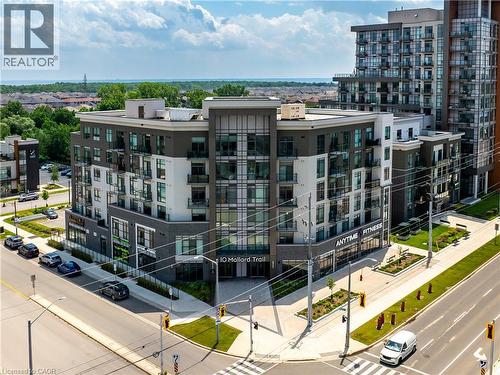 Modern multi-story building featuring balconies, large windows, and a prominent commercial storefront - 10 Mallard Trail Unit# 237, Waterdown, ON 
