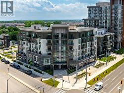 Modern multi-story building featuring balconies, large windows, and a prominent commercial storefront - 