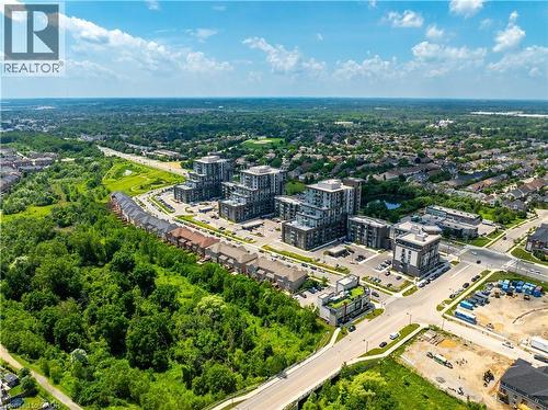 Aerial perspective showcasing multiple residential buildings, verdant green spaces, and an organized street network - 10 Mallard Trail Unit# 237, Waterdown, ON 