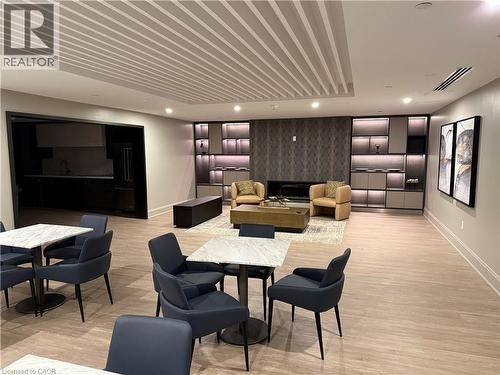 Wood-finish flooring throughout, featuring a linear pattern ceiling, built-in shelving with integrated lighting, and a modern fireplace - 10 Mallard Trail Unit# 237, Waterdown, ON 
