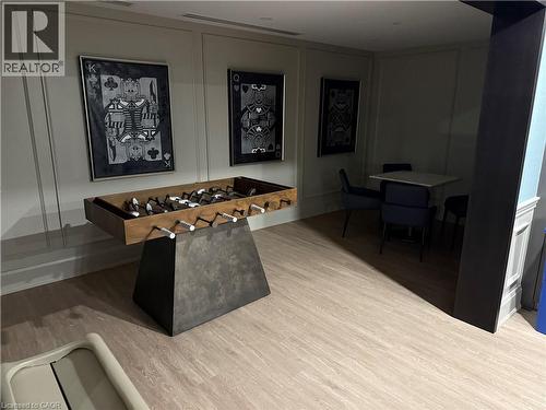 Wood-finish flooring throughout, white paneled accent walls, recessed lighting, and a built-in trim feature wall - 10 Mallard Trail Unit# 237, Waterdown, ON 