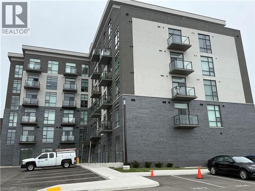 Contemporary multi-story building featuring a two-tone exterior, multiple private balconies with glass railings, and expansive windows - 10 Mallard Trail Unit# 237, Waterdown, ON 