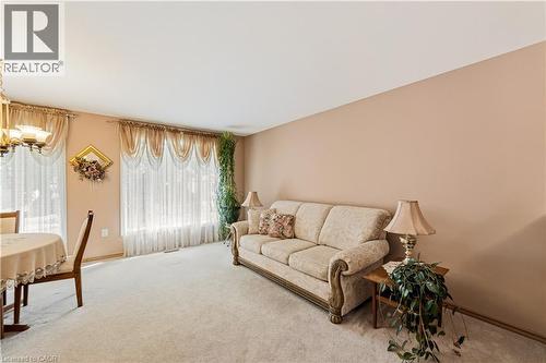 Spacious interior featuring a neutral color palette, 2 large windows and carpeted flooring - 450 Brigadoon Drive, Hamilton, ON 