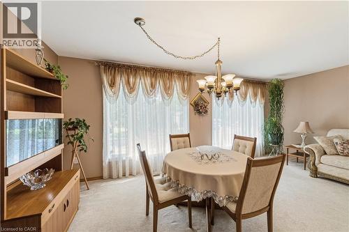 Spacious dining area featuring a brass chandelier, light-toned wall paint and light carpeting - 450 Brigadoon Drive, Hamilton, ON 