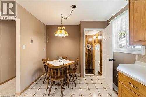 Kitchenette featuring patterned tile flooring, a wall-mounted light fixture, and a window with blinds - 450 Brigadoon Drive, Hamilton, ON 