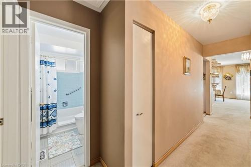 Hallway with linen closet and light-toned wall paint, 3 piece bathroom, original tiling still in great shape, vinyl flooring - 450 Brigadoon Drive, Hamilton, ON 