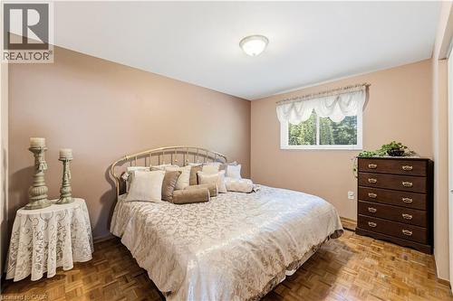 Primary Bedroom featuring wood-finish parquet flooring, window, closet and neutral-toned walls - 450 Brigadoon Drive, Hamilton, ON 
