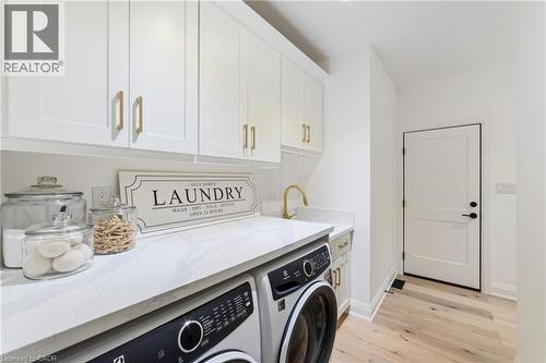 Laundry area with custom cabinetry and upgraded sink, not shown is additional cabinetry to the right of the man door to the garage, see video - 515 Hamilton Drive, Ancaster, ON 