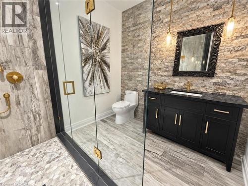 Glass-enclosed shower with gold-tone fixtures and large format tile - 515 Hamilton Drive, Ancaster, ON 