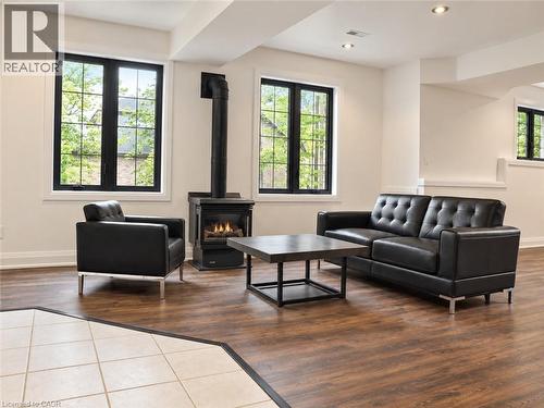 Wood-finish flooring, recessed lighting, and a freestanding gas fireplace create a comfortable atmosphere - 515 Hamilton Drive, Ancaster, ON 