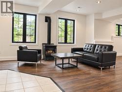 Wood-finish flooring, recessed lighting, and a freestanding gas fireplace create a comfortable atmosphere - 