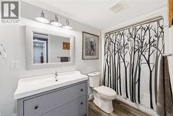 Full bath with laminate flooring, stand alone vanity and tub/shower - 
