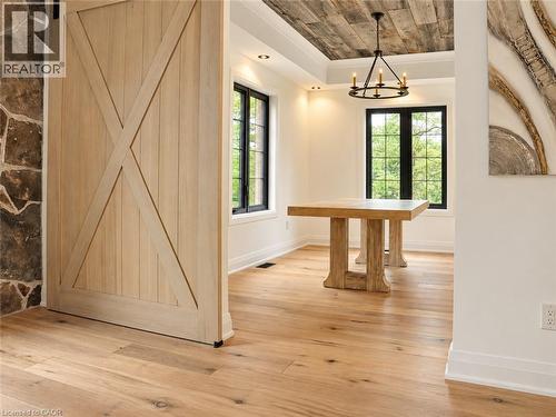 Bright, open interior showcasing wide-plank hardwood flooring throughout, custom barn-style sliding door with X-panel design, and abundant natural light from multiple black-framed windows - 515 Hamilton Drive, Ancaster, ON 