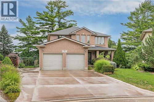 Brick exterior residence with a two-car garage, covered entry, and concrete driveway - 52 Archwood Crescent, Cambridge, ON 