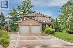 Brick exterior residence with a two-car garage, covered entry, and concrete driveway - 