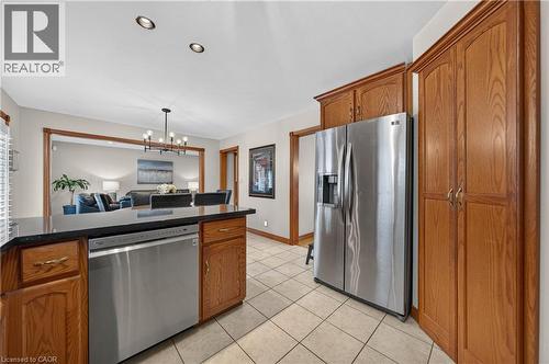 Kitchen featuring tile flooring, wood-finish cabinetry, stainless steel dishwasher, stainless steel refrigerator, and recessed lighting - 52 Archwood Crescent, Cambridge, ON 
