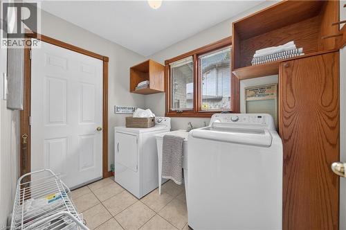 Tiled flooring, built-in wooden cabinetry, and a utility sink - 52 Archwood Crescent, Cambridge, ON 