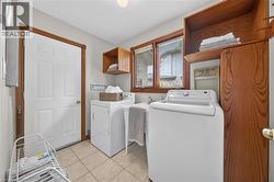 Tiled flooring, built-in wooden cabinetry, and a utility sink - 