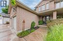Brick exterior with two-car garage, covered entry, double entry doors, and landscaping - 52 Archwood Crescent, Cambridge, ON 