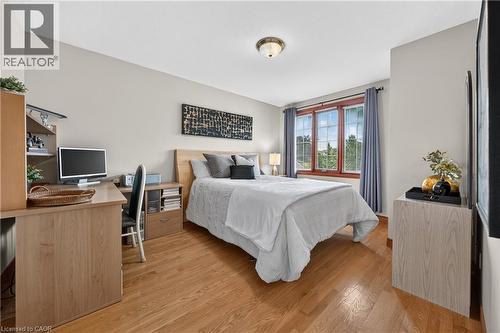 Hardwood flooring, neutral wall tones, three-panel window, flush mount ceiling fixture, and built-in desk with shelving - 52 Archwood Crescent, Cambridge, ON 