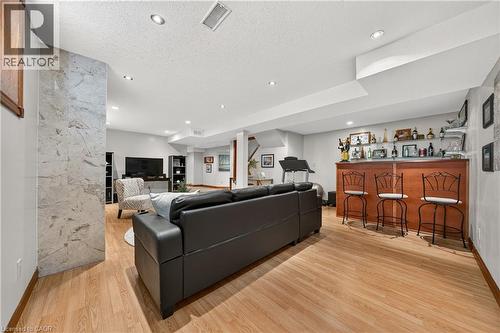 Wood-finish flooring throughout, recessed lighting, built-in wet bar, and a stone-clad architectural feature - 52 Archwood Crescent, Cambridge, ON 