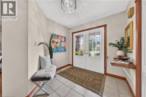 Double entry doors with decorative glass panels, tile flooring, and wood trim accents - 52 Archwood Crescent, Cambridge, ON 