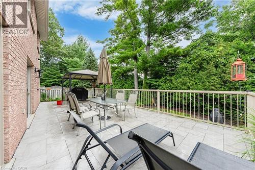 Expansive outdoor patio with stone pavers, a metal railing, and a permanent gazebo structure - 52 Archwood Crescent, Cambridge, ON 