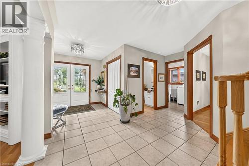Entry foyer featuring double entry doors with leaded glass, column details, built-in shelving, and tile flooring - 52 Archwood Crescent, Cambridge, ON 