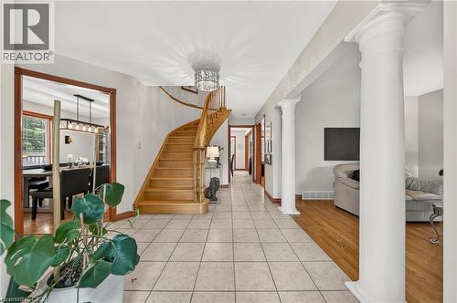 Foyer featuring tile flooring, a curved wood staircase, and decorative columns - 52 Archwood Crescent, Cambridge, ON 