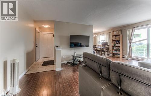 Living room with a chandelier and dark wood finished floors - 283 Fairway Road N Unit# 501, Kitchener, ON 