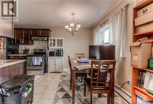 Dining room featuring light tile patterned flooring, a chandelier, and baseboard heating - 283 Fairway Road N Unit# 501, Kitchener, ON 